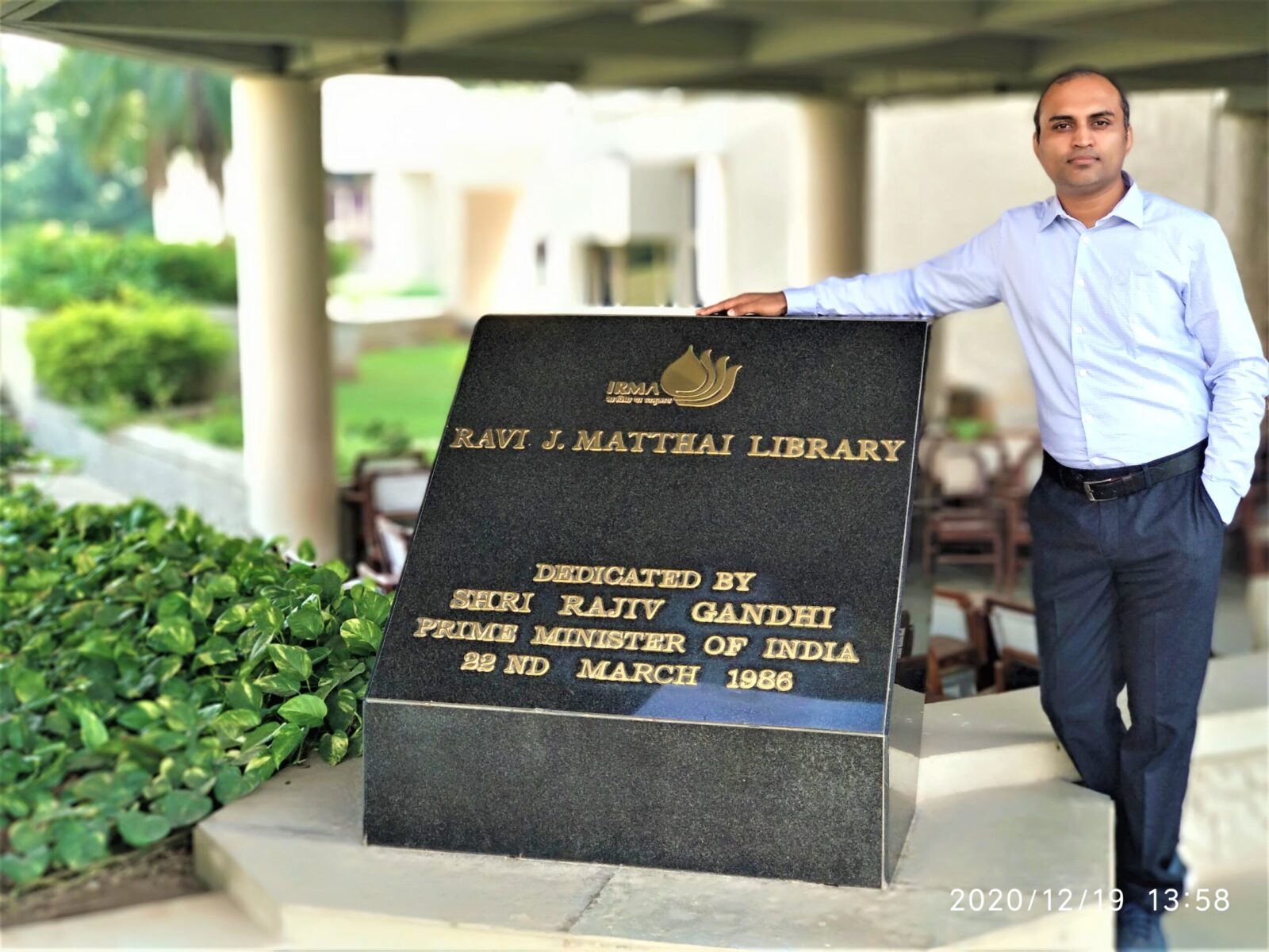 award winner standing in front of university