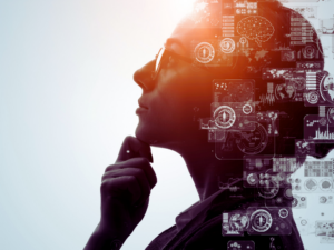 Side profile of a person with glasses resting their chin on their hand, overlaid with translucent holographic data and charts.